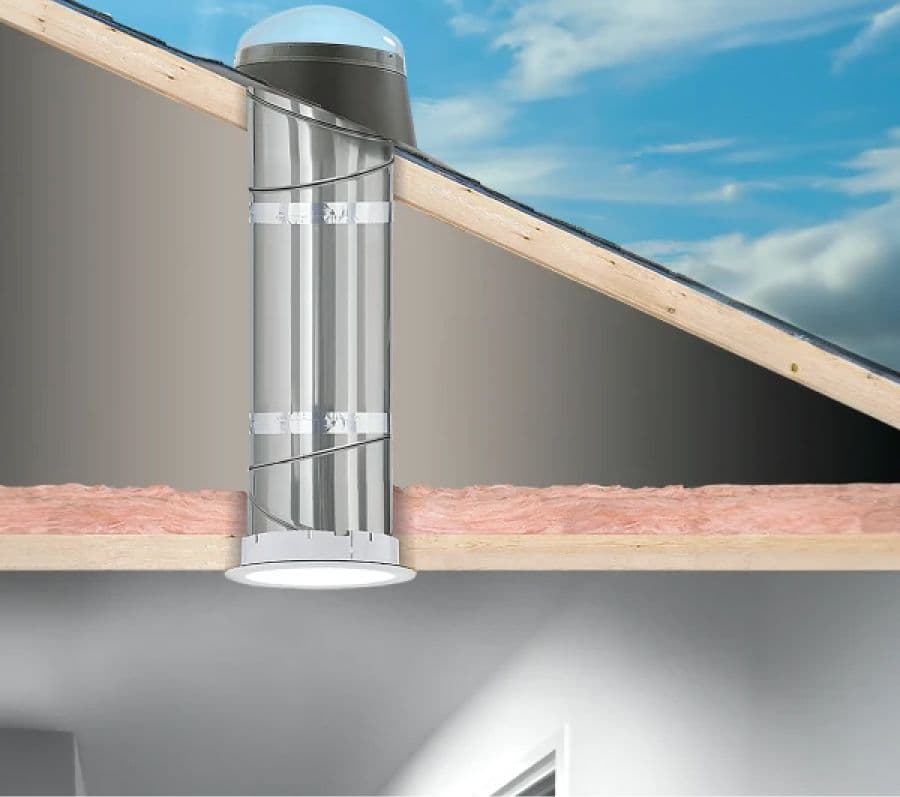 Cutaway of a home showing a solar tube skylight. Sunlight enters through a dome on the roof, travels down a reflective tube, illuminating the room.